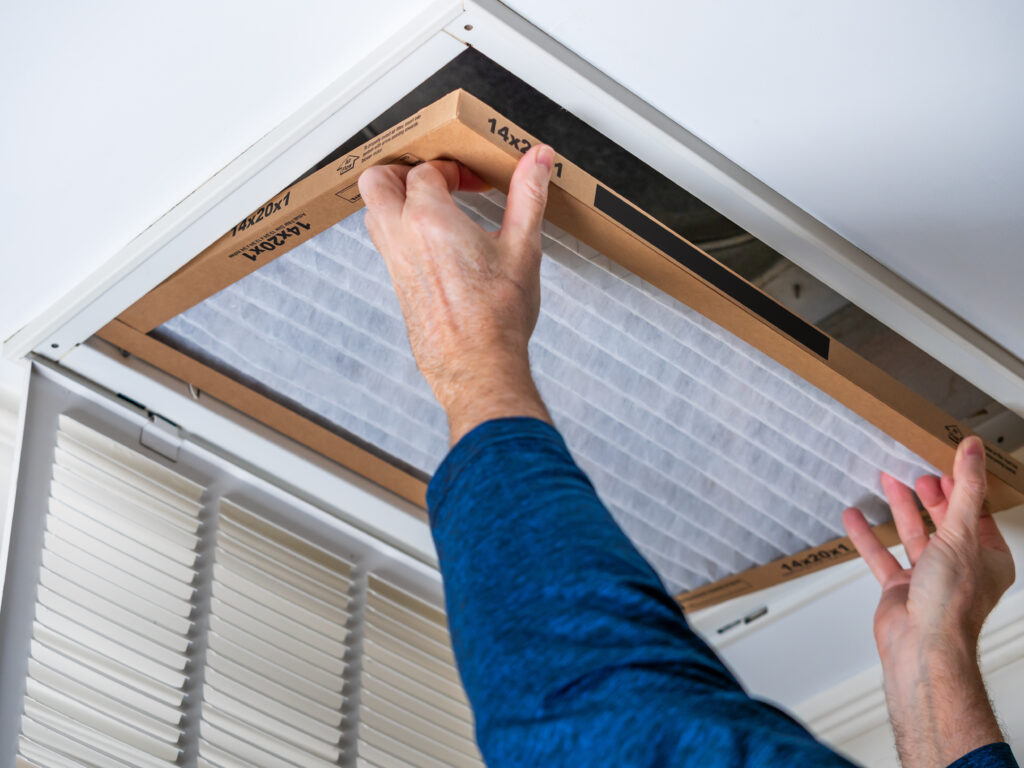HVAC technician replacing a home air filter in West Covina