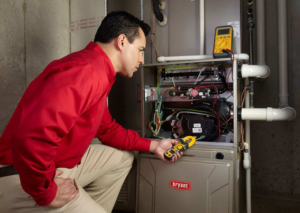 Heating technician diagnosing a furnace repair in West Covina