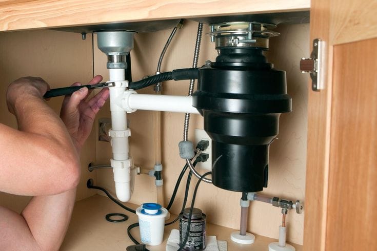 Plumber repairing a garbage disposal in West Covina