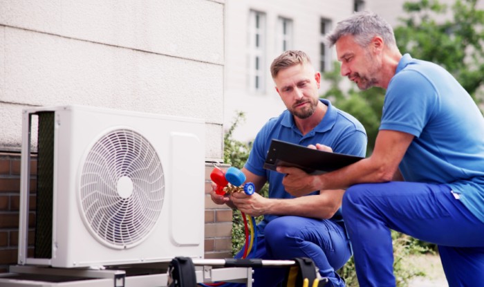 HVAC technicians installing an outdoor air conditioning unit in West Covina